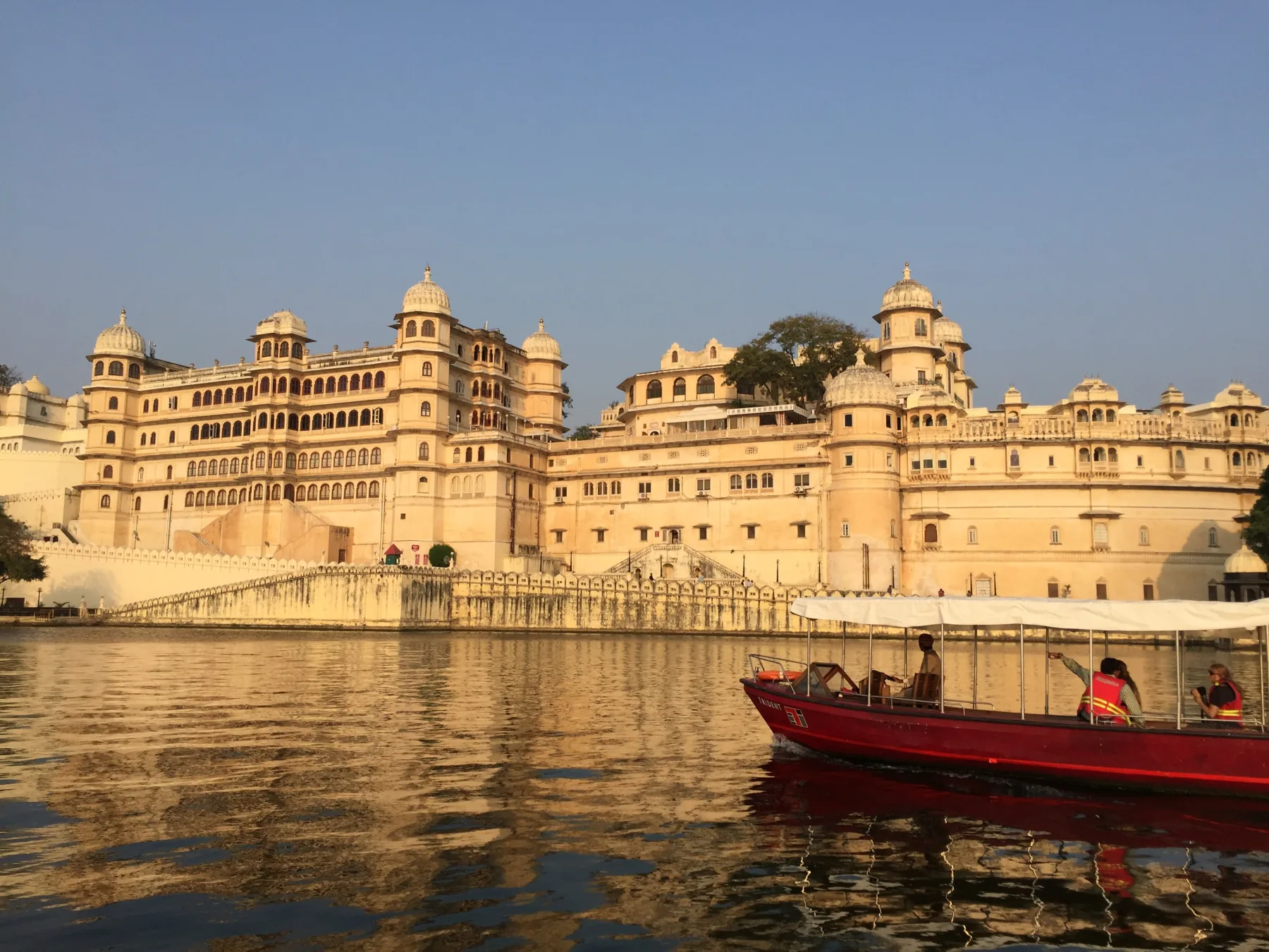 City Palace d’Udaipur au bord du lac avec une barque rouge