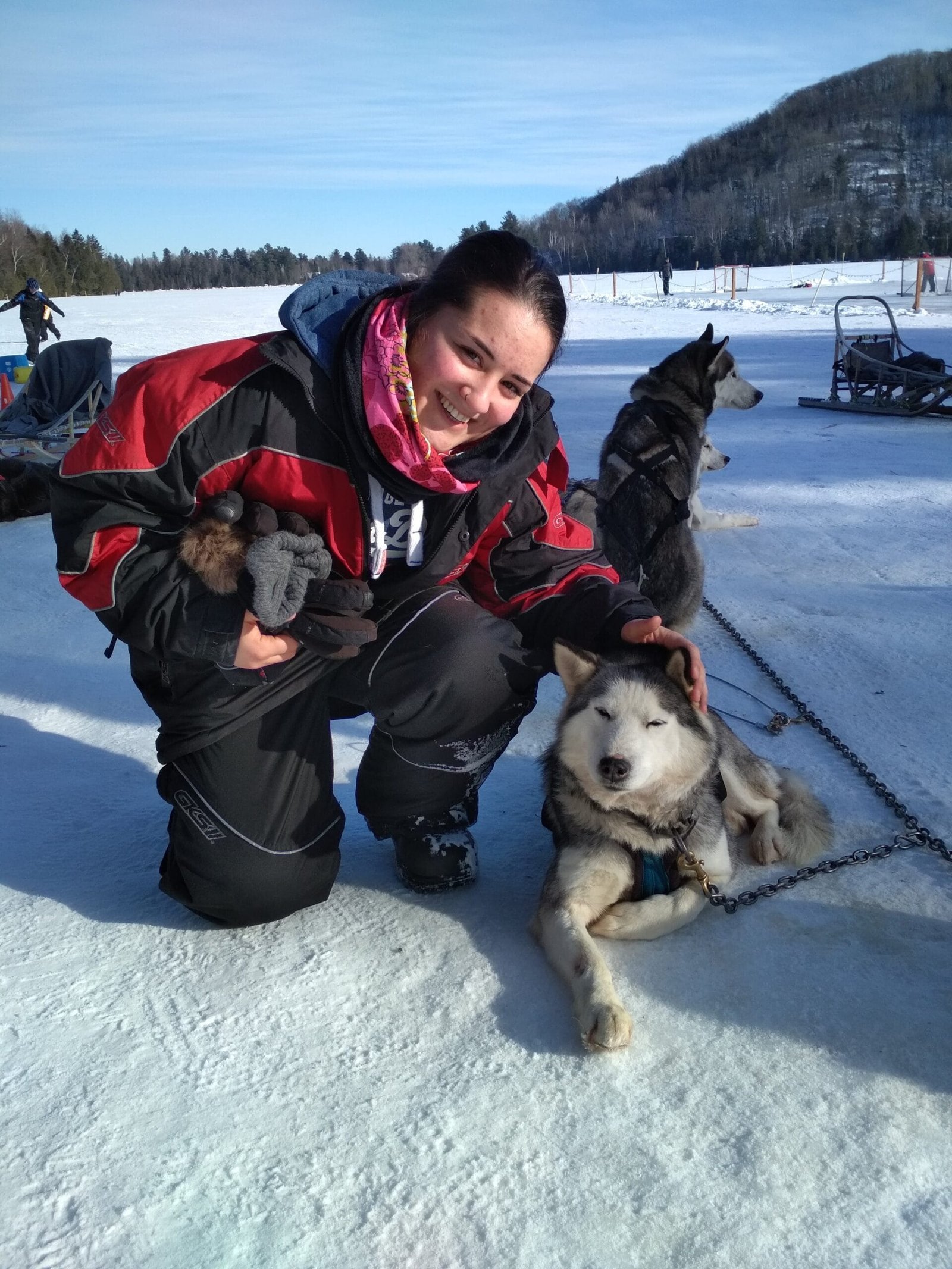 Laetitia avec des chiens de traîneau huskies dans la neige